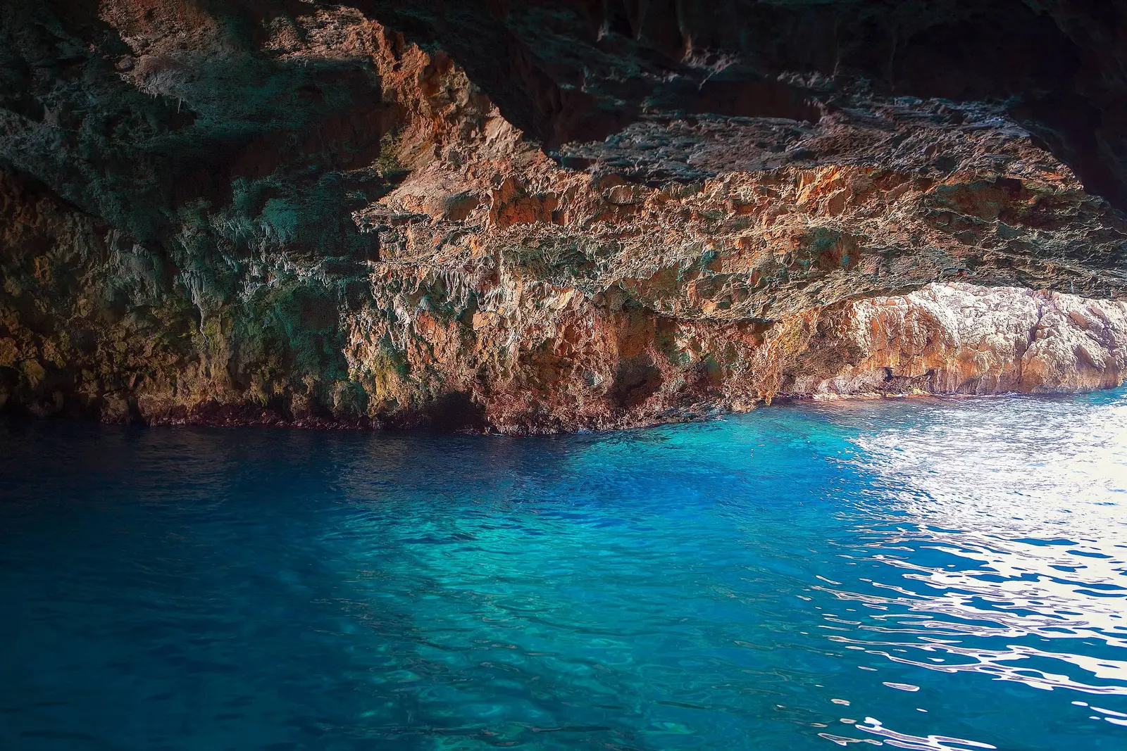 Rock walls and turquoise water inside the Blue Cave