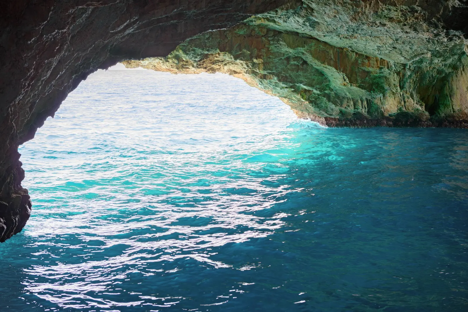 Sunlit turquoise water at the mouth of the Blue Cave on Luštica
