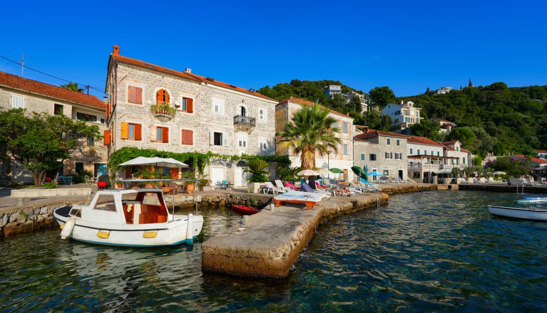 Stone waterfront houses, a small working boat and terraces in Rose