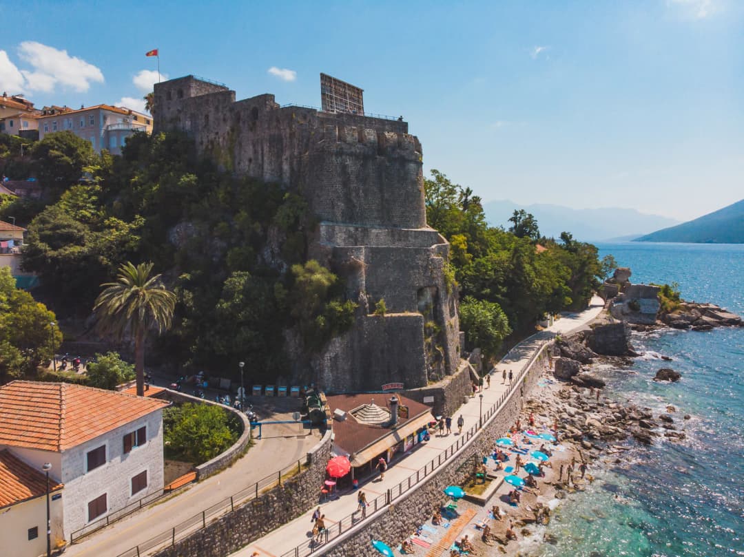Forte Mare fortress rising above the shore promenade and beach in Herceg Novi