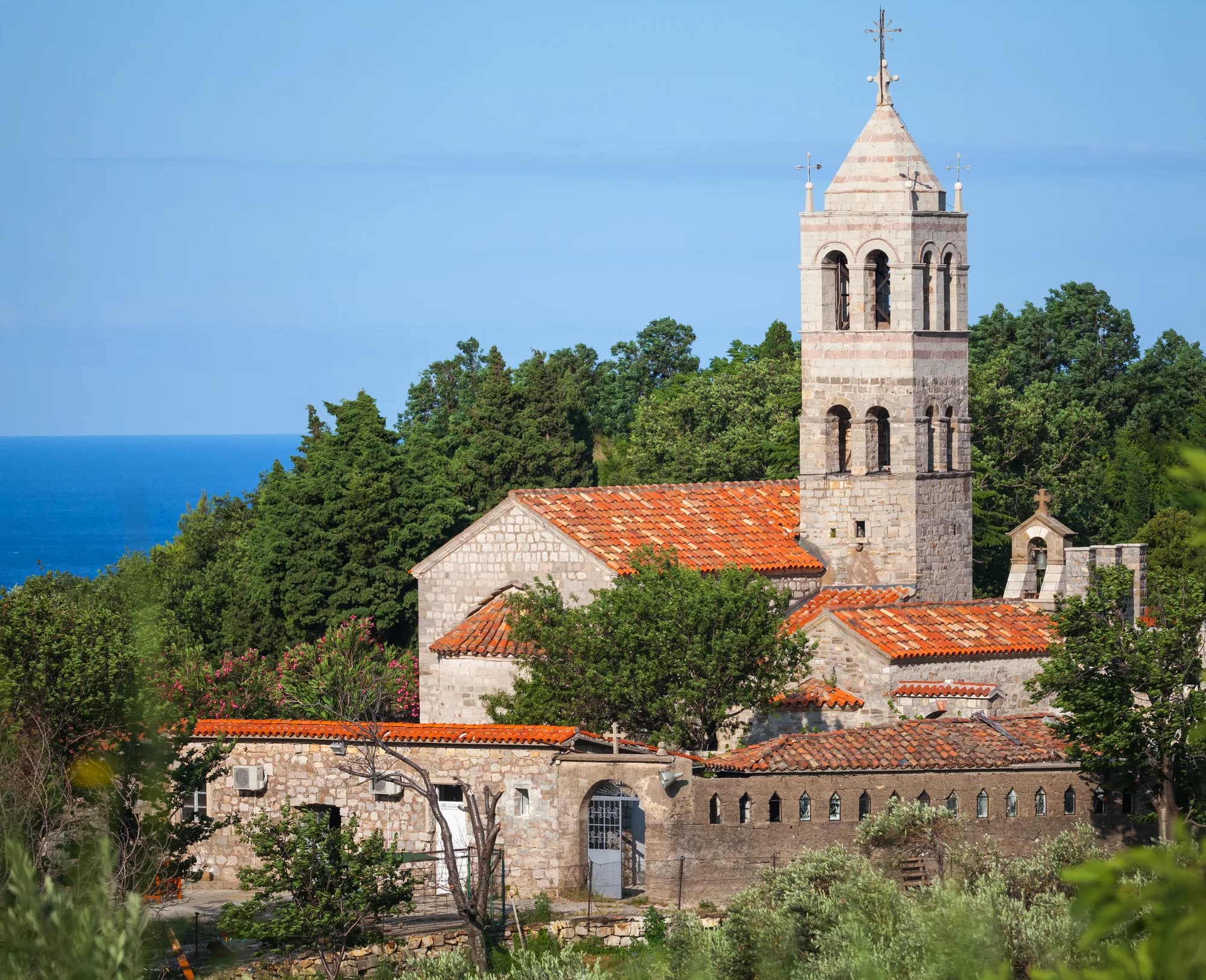 Manastir Reževići i bokal vina na kamenom stubu