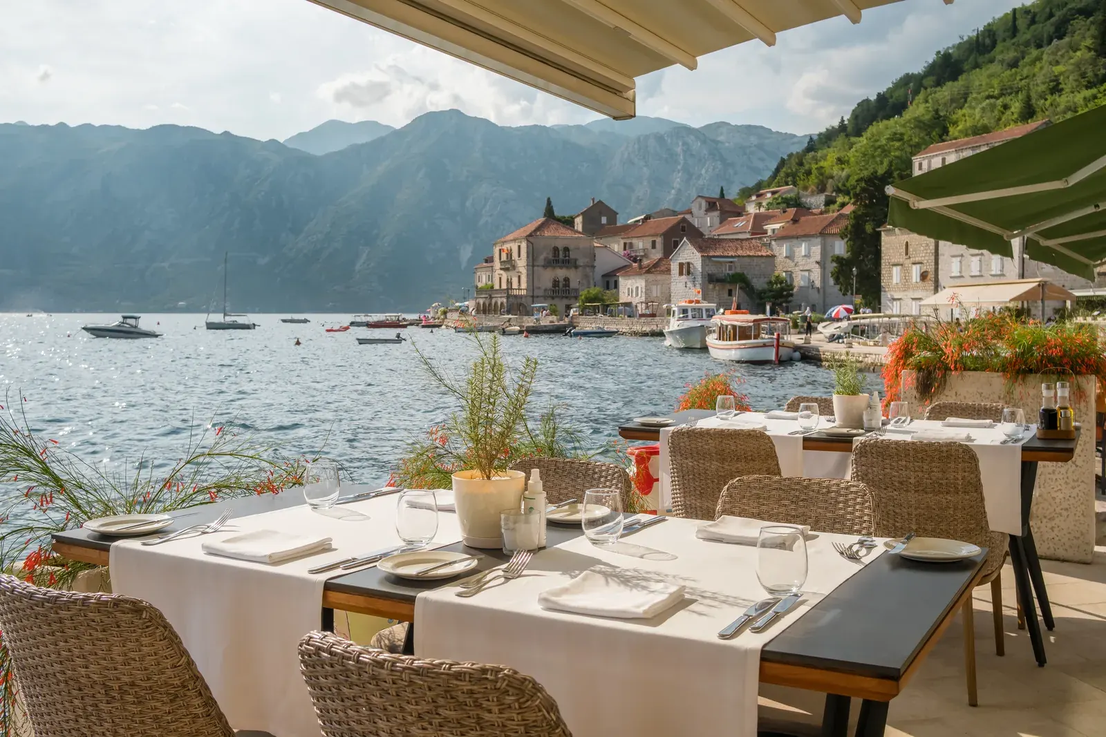 A waterfront restaurant table set with a view over Perast and the Bay of Kotor