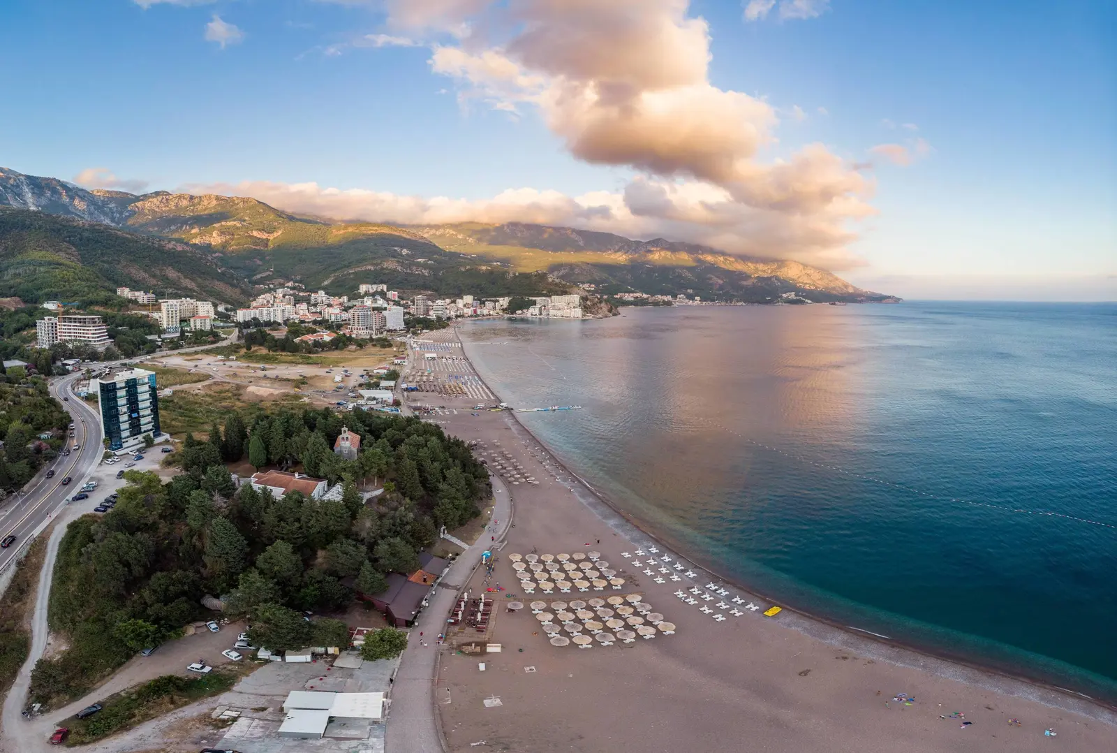 Pogled iz vazduha duž plaže Bečići prema Rafailovićima, sa planinama u pozadini